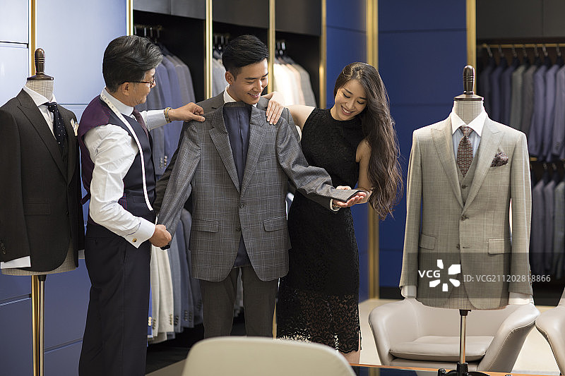年轻情侣在服装店挑选西装图片素材