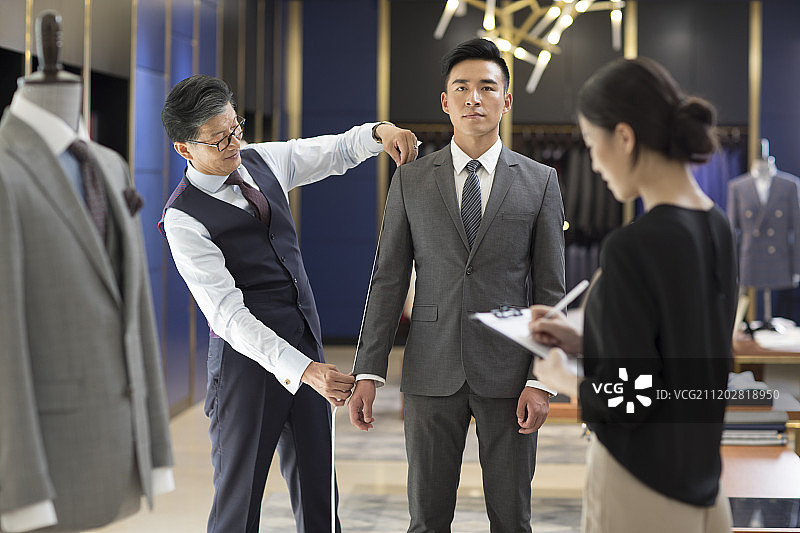 服装设计师为顾客量尺寸图片素材