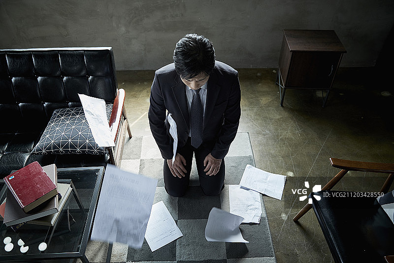 商人跪在工作场所被训斥的照片图片素材