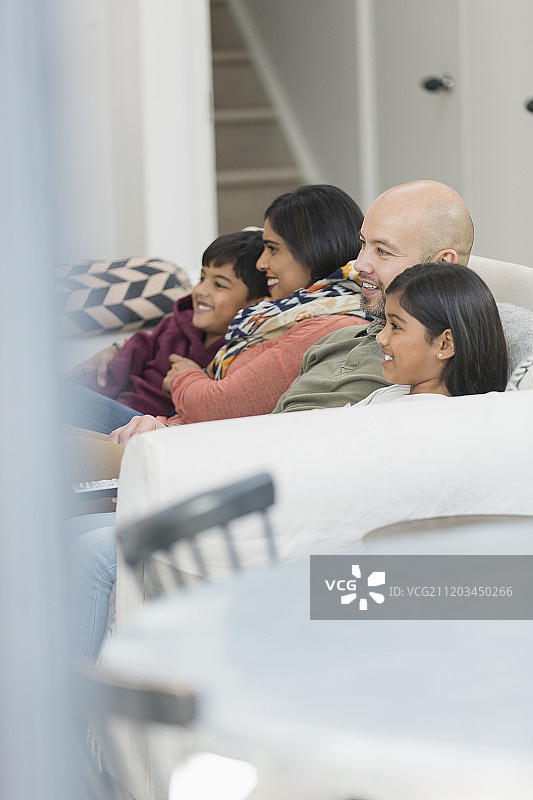 家庭在客厅沙发上看电视图片素材