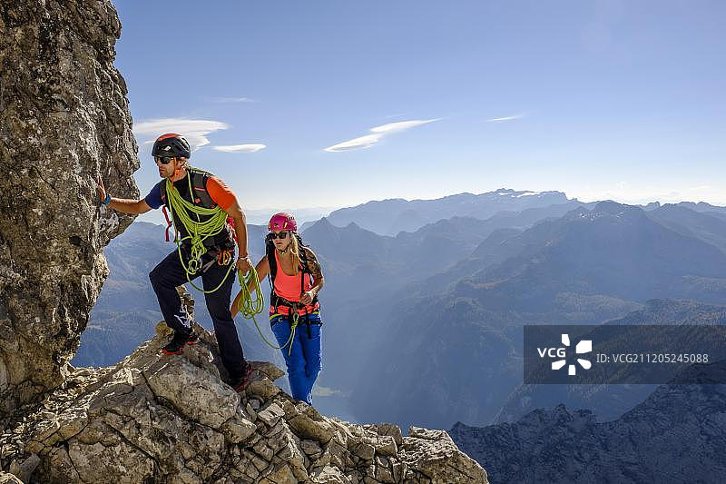 德国瓦茨曼山，登山向导与年轻女人攀岩图片素材