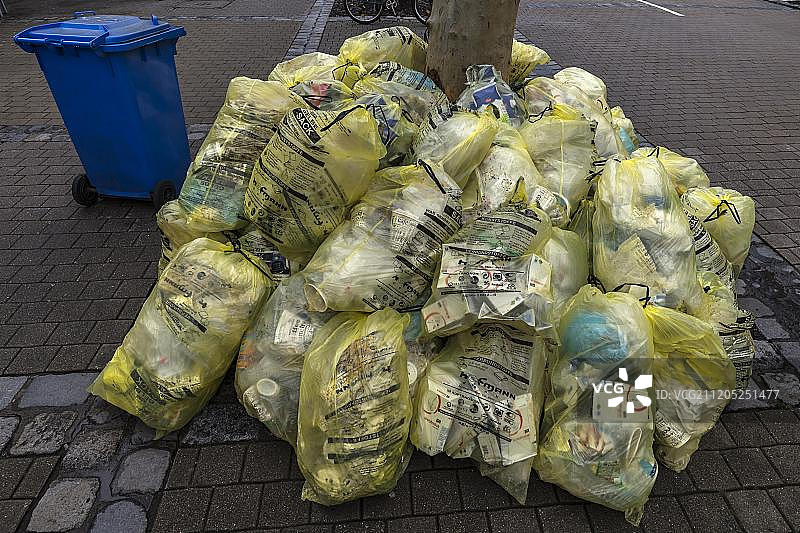 德国巴伐利亚埃尔兰根步行区堆叠的黄色垃圾袋图片素材