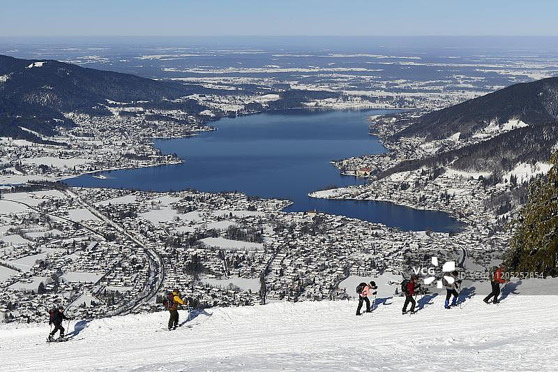 徒步旅行者和滑雪者冬季攀登瓦尔伯格，泰根湖后，罗塔赫-埃根，上巴伐利亚，巴伐利亚，德国，欧洲图片素材