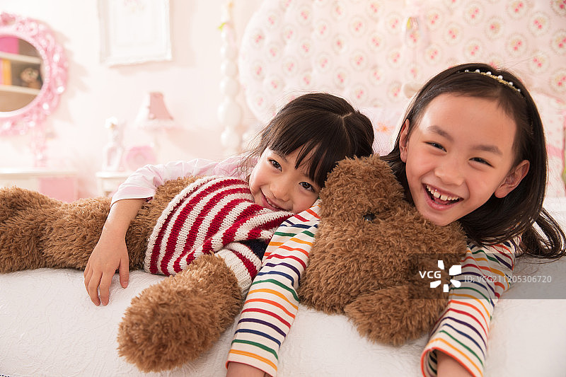 可爱的小女孩在床上玩耍图片素材