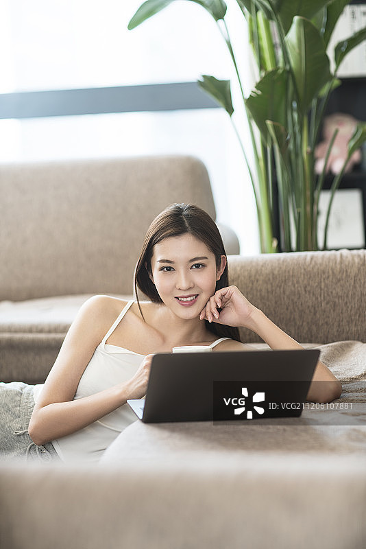 年轻女子在家使用笔记本电脑图片素材
