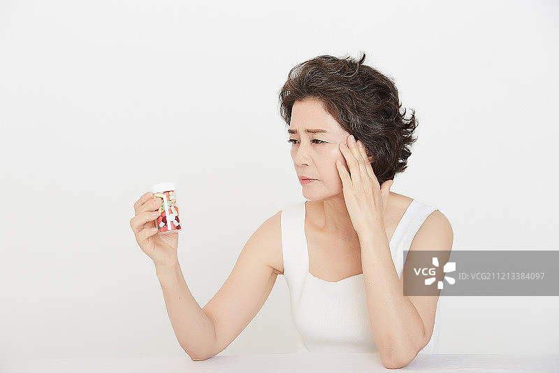 中年妇女，更年期，健康疾病，头痛，药丸图片素材