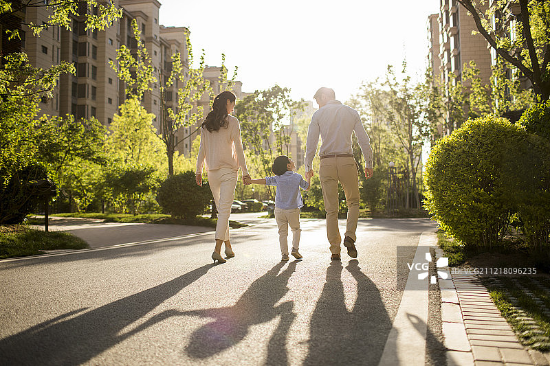 快乐的年轻家庭手牵手散步图片素材