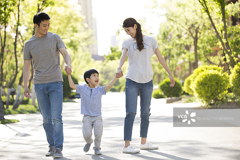快乐的年轻家庭手牵手散步图片素材