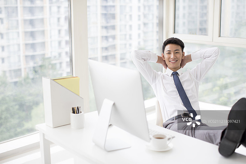 年轻商务男士在办公室放松休息图片素材