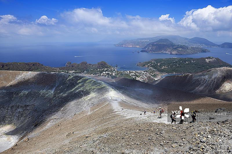 徒步旅行者在火山口边缘俯瞰利帕里岛，意大利西西里图片素材