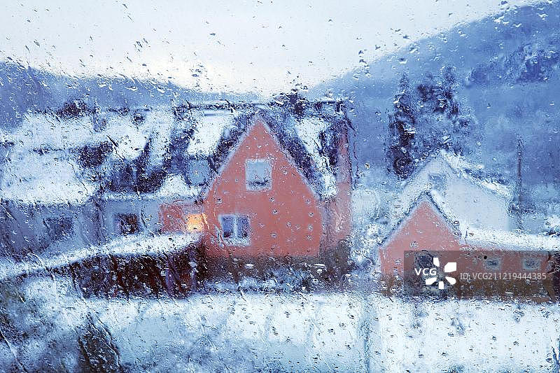 窗格上的雨滴：德国维滕市冬季房屋的模糊景色图片素材