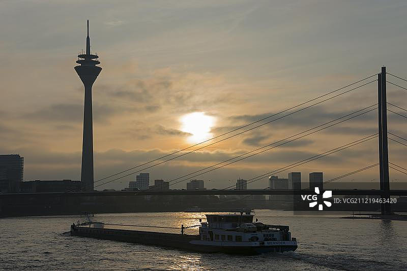 德国北莱茵-威斯特法伦州杜塞尔多夫莱茵河上的逆光货船图片素材