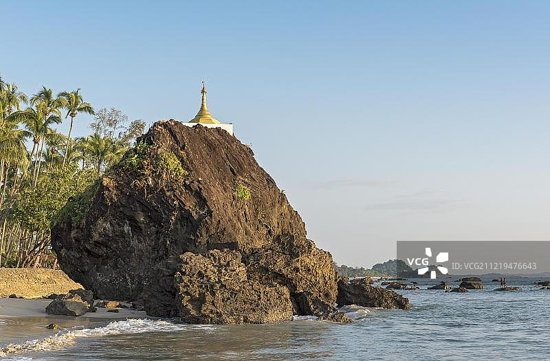 缅甸若开邦加帕里海滩海岸线上岩石上的金色佛塔图片素材