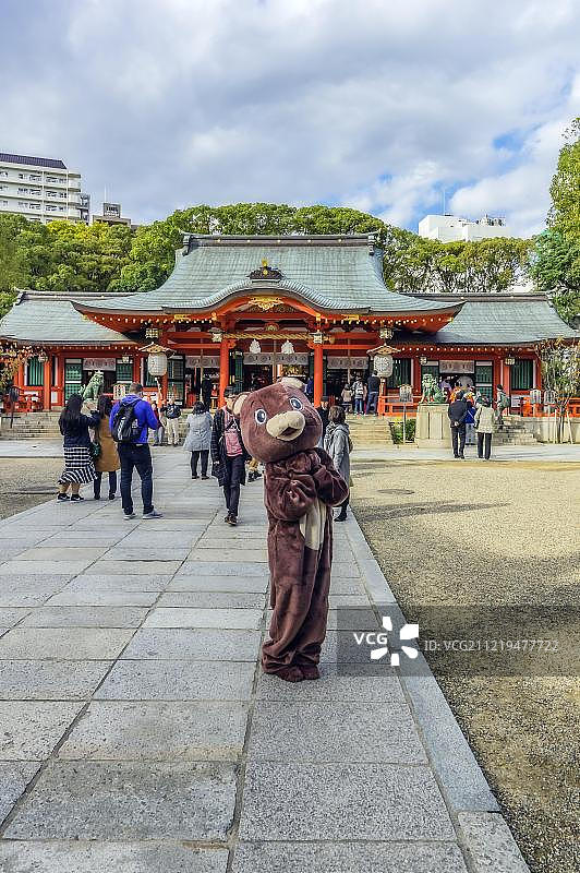 游客在神户生田神社前与毛绒熊合影，日本，亚洲图片素材