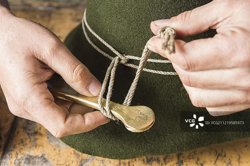 在制帽工坊，使用铁工具收紧羊毛毡帽的成型绳图片素材