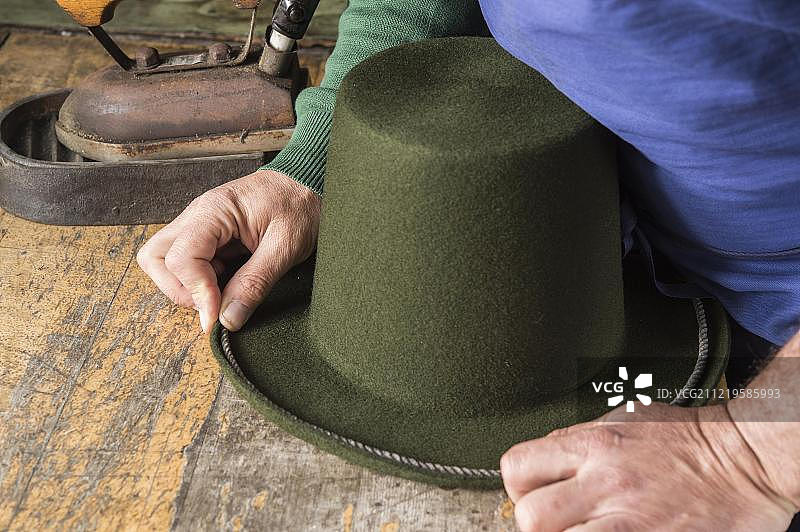 手持绳索的干羊毛毡帽，制帽工坊，奥地利图片素材