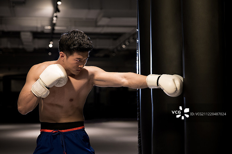 青年男子在训练房练习拳击图片素材