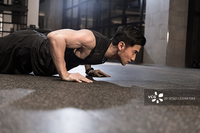 青年男子在健身房做俯卧撑图片素材