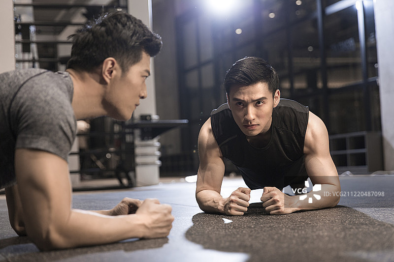 两个年轻男子在健身房做平板支撑运动图片素材