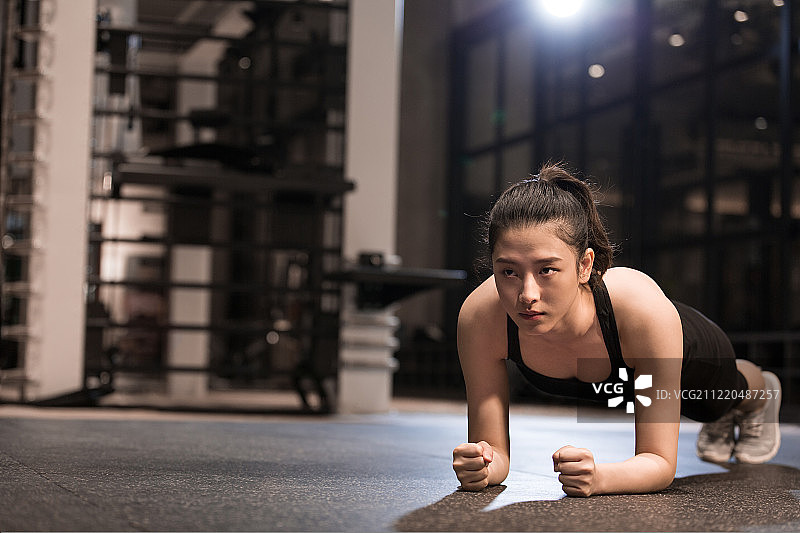 青年女子在健身房做平板支撑运动图片素材