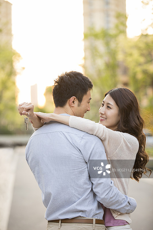 幸福的年轻情侣拿着新房钥匙图片素材