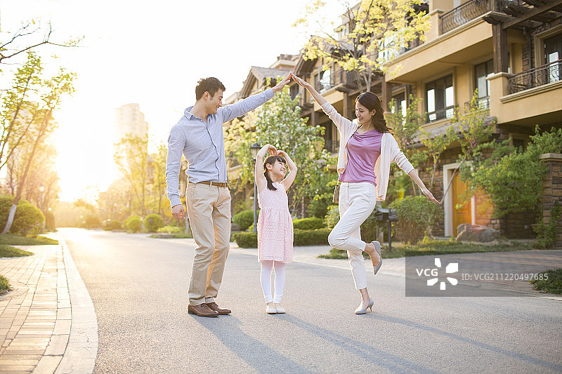 幸福的年轻家庭在别墅小区玩耍图片素材