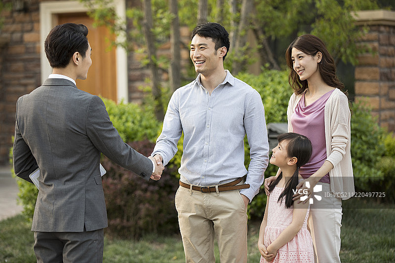 开心的年轻家庭和房产经纪人握手图片素材