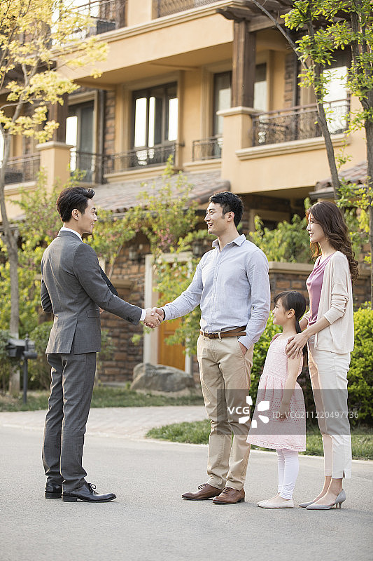 开心的年轻家庭和房产经纪人握手图片素材