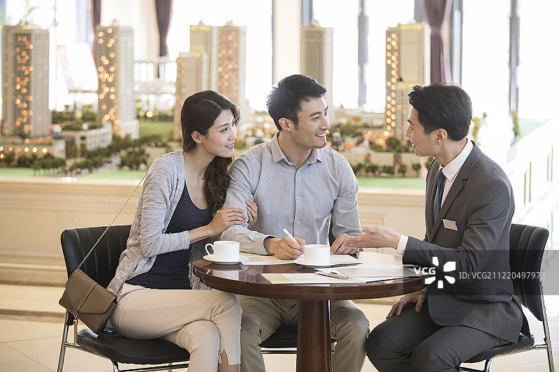 年轻夫妇在售楼处买新房图片素材