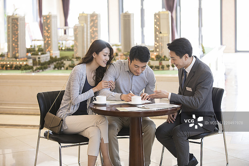 年轻夫妇在售楼处买新房图片素材