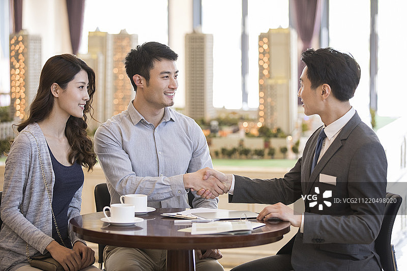 年轻夫妇在售楼处买新房图片素材