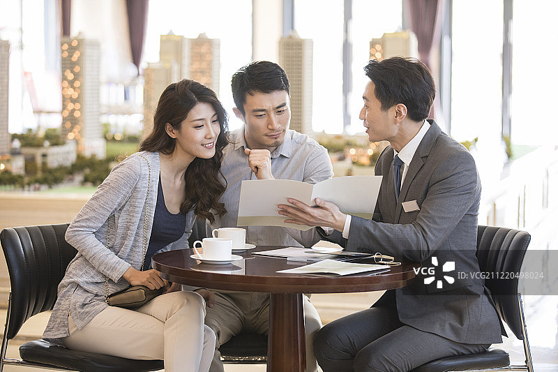 年轻夫妇在售楼处买新房图片素材