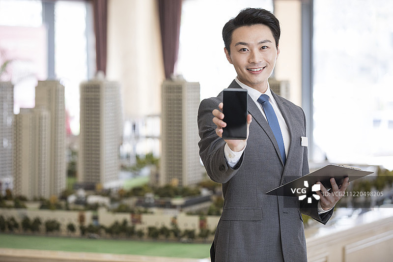 自信的房产经纪人展示手机图片素材