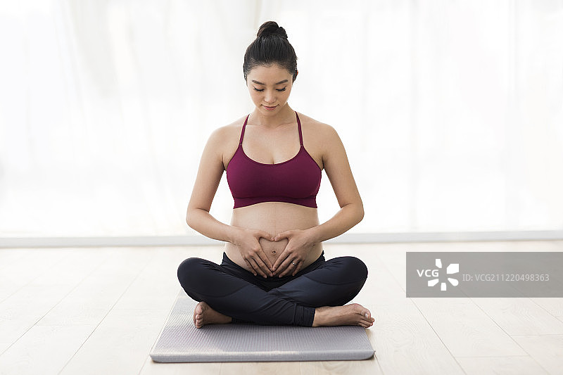 年轻孕妇手放在肚子上图片素材