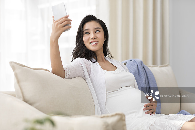 年轻孕妇使用手机图片素材
