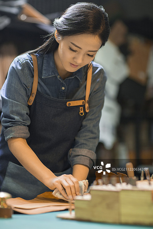 手工皮具匠人在工作室里工作图片素材