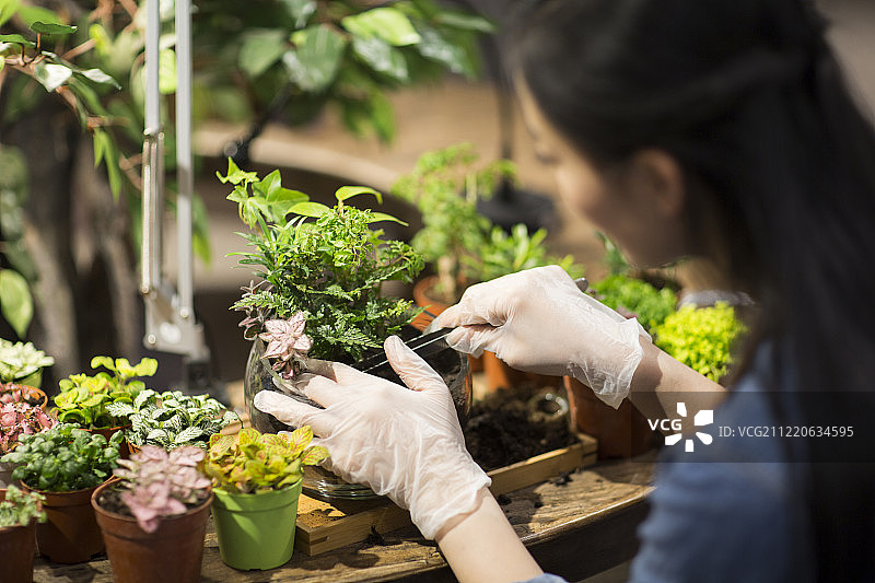 年轻女子在花店里工作图片素材