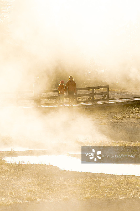 母亲和女儿参观美国怀俄明州黄石国家公园的西拇指间歇泉盆地图片素材