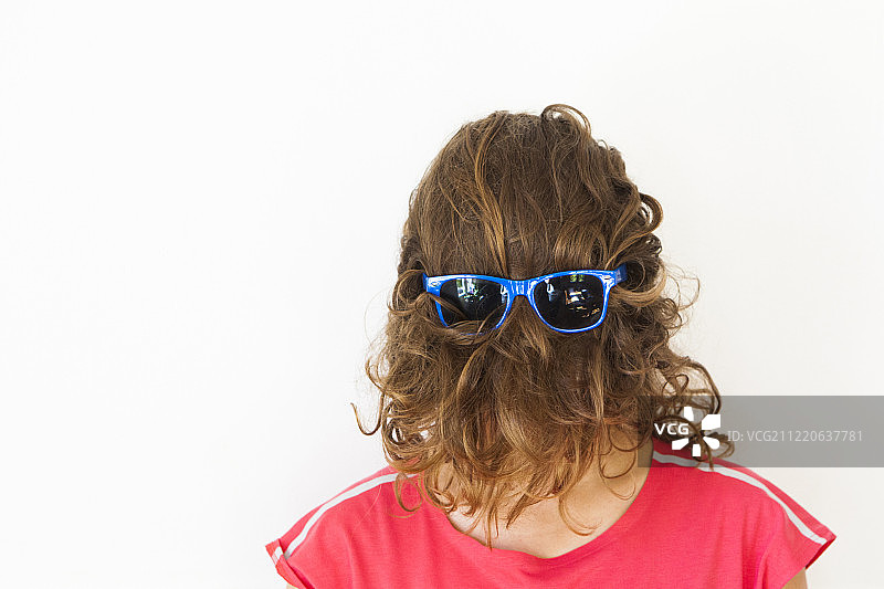 戴蓝色太阳镜，遮面的女士影棚照图片素材