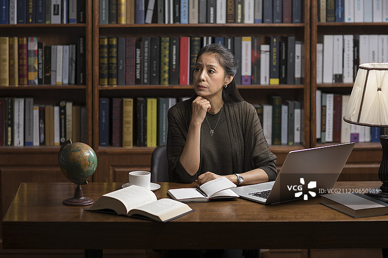 优雅的中年女士在书房思考图片素材