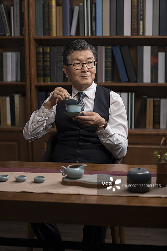 成功商务男士在书房品茶图片素材