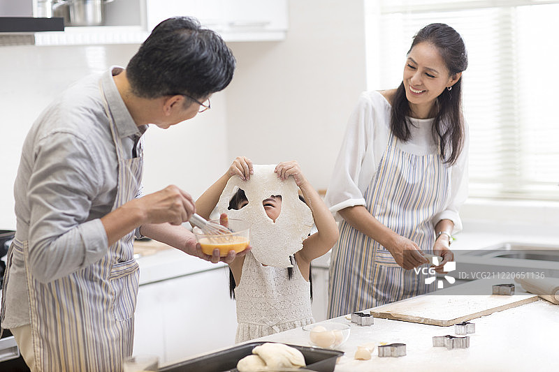 快乐小女孩和爷爷奶奶在厨房制作饼干图片素材