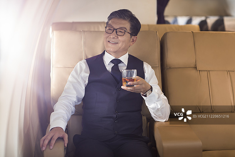 商务男士在机舱里喝酒图片素材