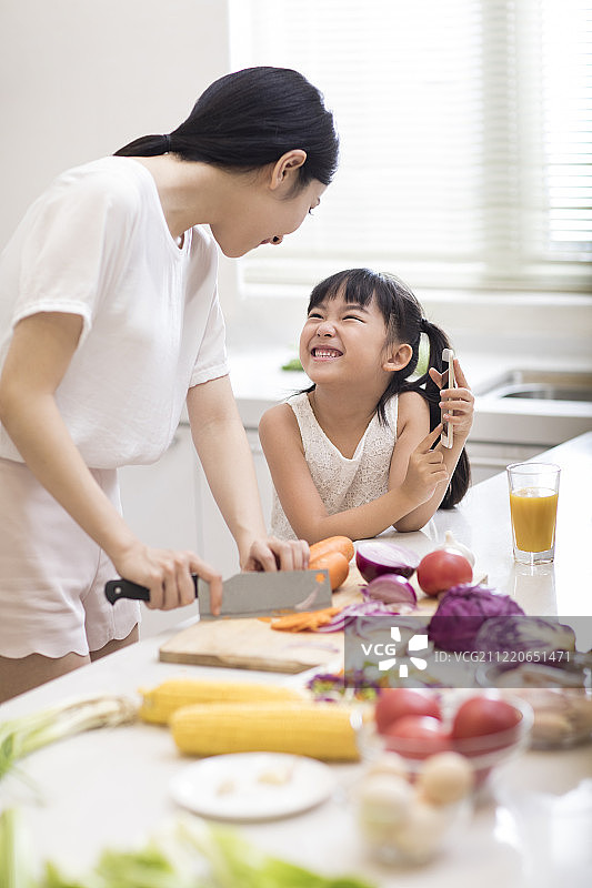 快乐小女孩和妈妈在厨房做饭图片素材