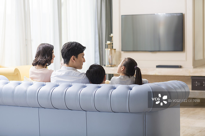 一家四口在客厅看电视图片素材