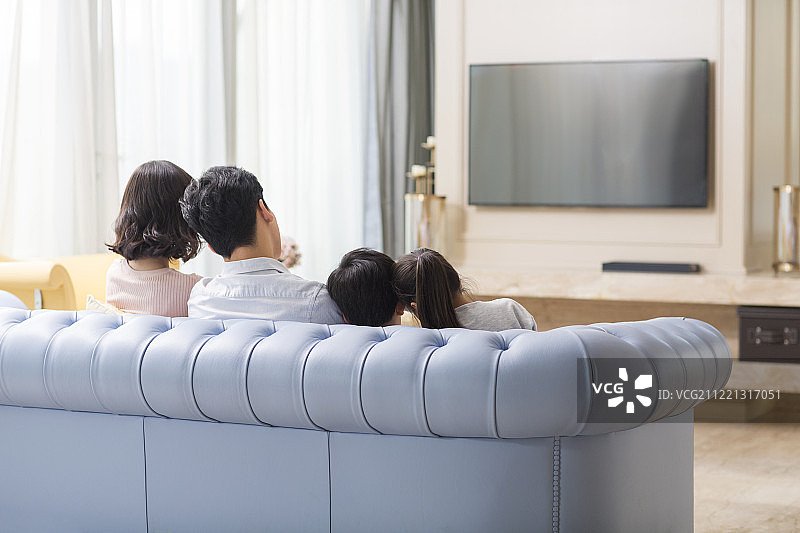 一家四口在客厅看电视图片素材