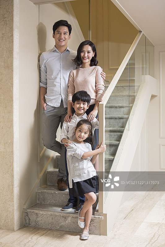 楼梯上的快乐年轻家庭肖像图片素材