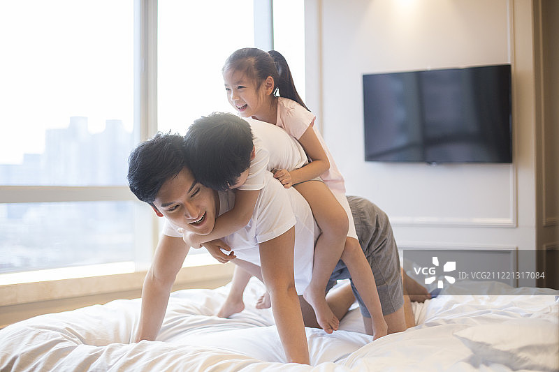 快乐年轻家庭在床上嬉戏图片素材