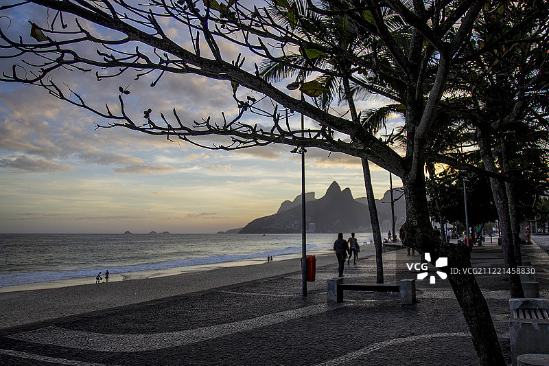 黄昏时分的海边长廊，背景是山脉图片素材