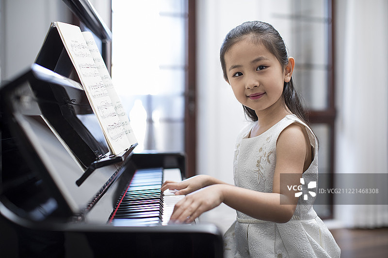 快乐的小女孩弹钢琴图片素材